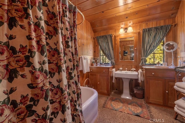 bathroom featuring a tub to relax in, lofted ceiling, wood ceiling, and wooden walls