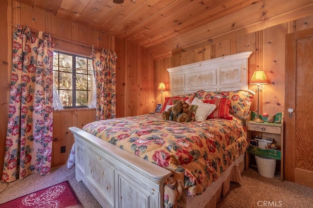 carpeted bedroom with wooden ceiling and wooden walls