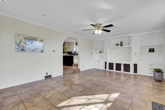 unfurnished living room with ceiling fan, built in shelves, and ornamental molding