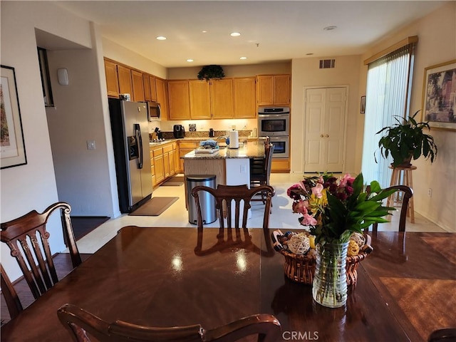 kitchen featuring appliances with stainless steel finishes, a center island, and light stone counters