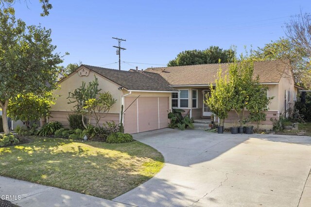 ranch-style house featuring a garage and a front yard