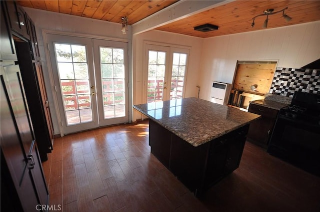 kitchen with a kitchen island, wood ceiling, black gas range oven, french doors, and light stone counters