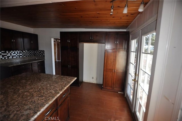 kitchen featuring backsplash, wood ceiling, dark stone countertops, and dark hardwood / wood-style floors