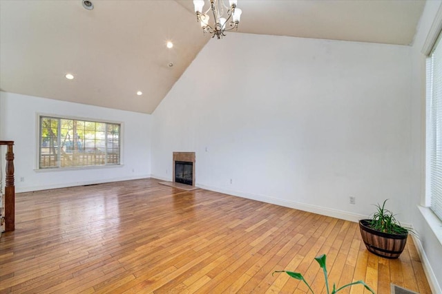 unfurnished living room featuring a chandelier, light hardwood / wood-style floors, and high vaulted ceiling