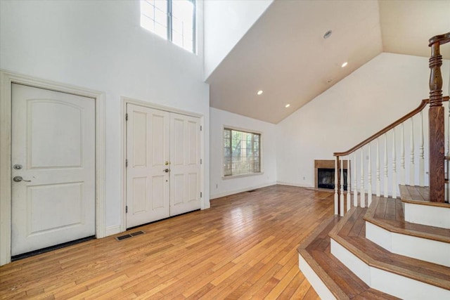 entrance foyer featuring high vaulted ceiling and light hardwood / wood-style flooring