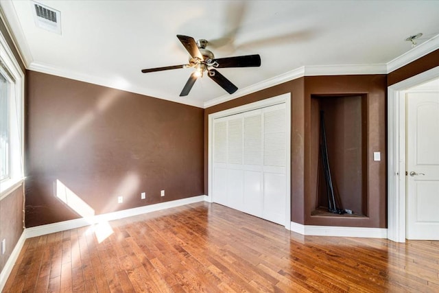 unfurnished bedroom featuring ceiling fan, crown molding, and hardwood / wood-style floors