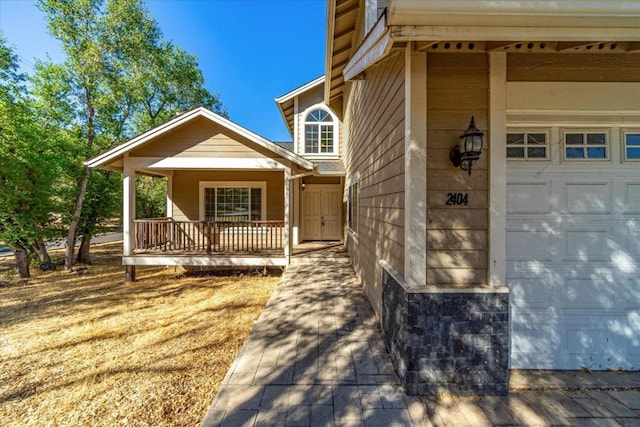 property entrance featuring a garage and a porch