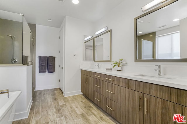 bathroom featuring vanity, shower with separate bathtub, and hardwood / wood-style flooring