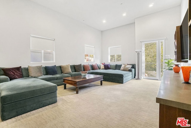 carpeted living room with a towering ceiling