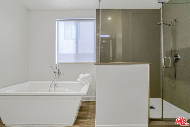 bathroom featuring hardwood / wood-style floors and shower with separate bathtub