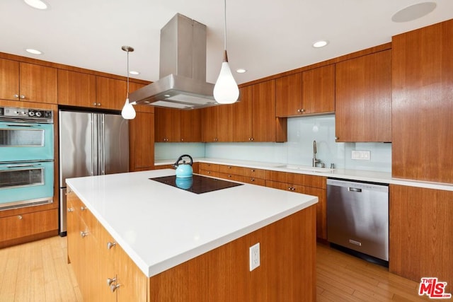 kitchen with decorative light fixtures, a center island, black appliances, sink, and island exhaust hood