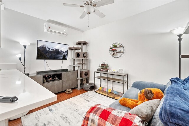 living room with ceiling fan, wood-type flooring, and a wall mounted air conditioner