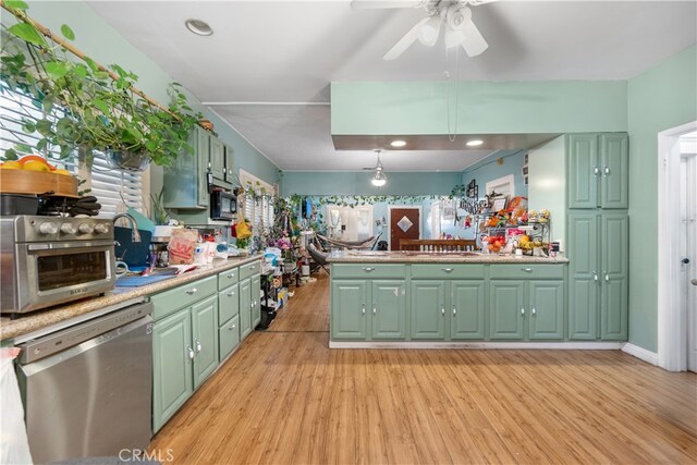 kitchen featuring ceiling fan, light wood-type flooring, dishwasher, and green cabinetry