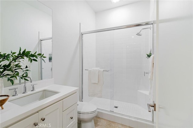 bathroom featuring toilet, a shower with door, and vanity