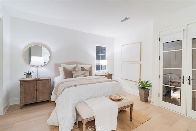 bedroom featuring french doors and light hardwood / wood-style flooring