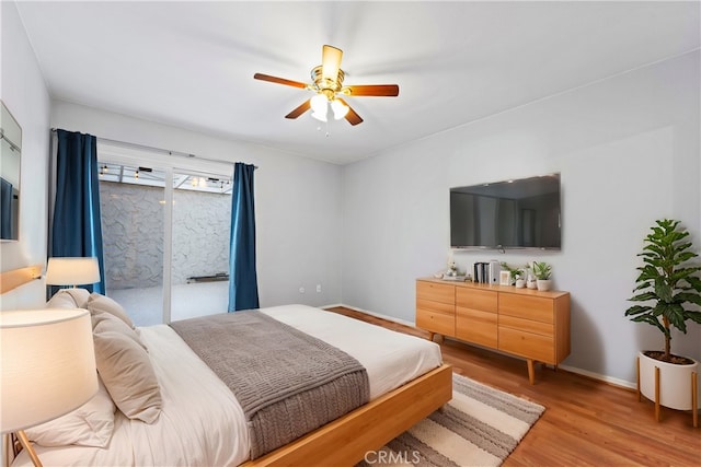 bedroom with ceiling fan, wood-type flooring, and access to outside