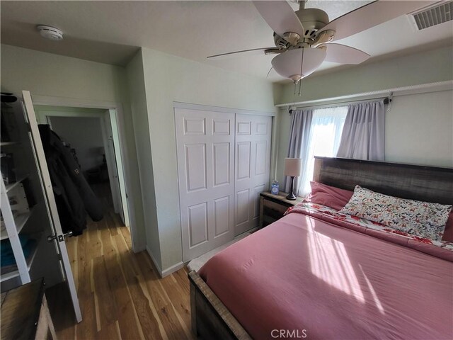 bedroom with ceiling fan, a closet, and hardwood / wood-style flooring