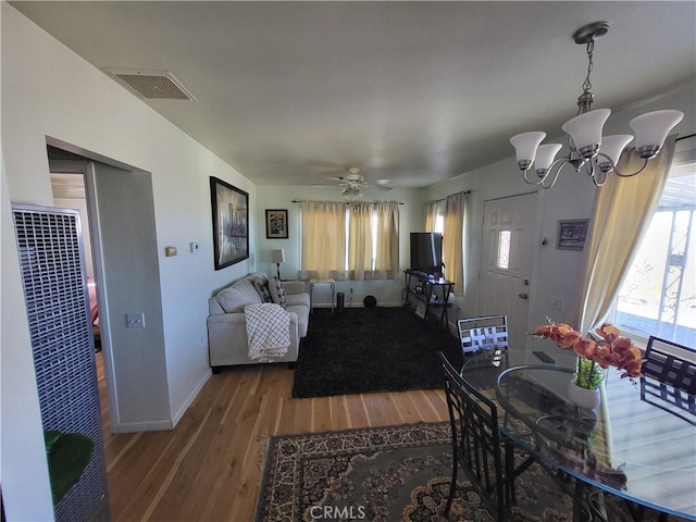 dining space featuring hardwood / wood-style flooring and ceiling fan with notable chandelier