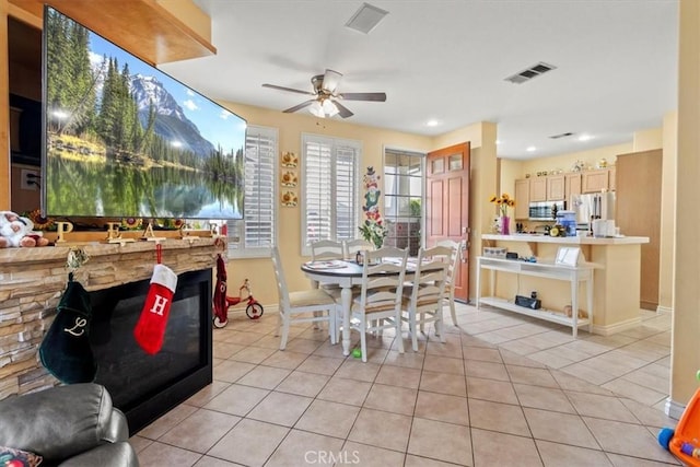 dining room with light tile patterned floors, baseboards, visible vents, and a ceiling fan