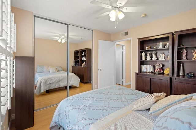 bedroom with a ceiling fan, a closet, visible vents, and light wood finished floors