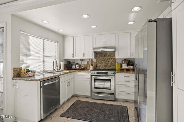 kitchen with sink, white cabinetry, appliances with stainless steel finishes, and dark stone counters