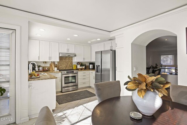 kitchen with sink, light tile patterned floors, stainless steel appliances, white cabinets, and stone countertops