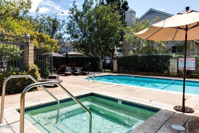 view of pool with a patio area and a community hot tub