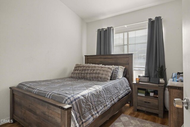 bedroom with dark hardwood / wood-style floors and lofted ceiling