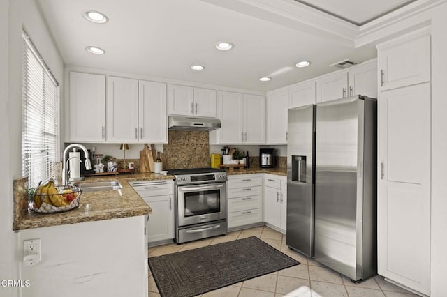 kitchen featuring light tile patterned floors, white cabinetry, appliances with stainless steel finishes, stone counters, and sink