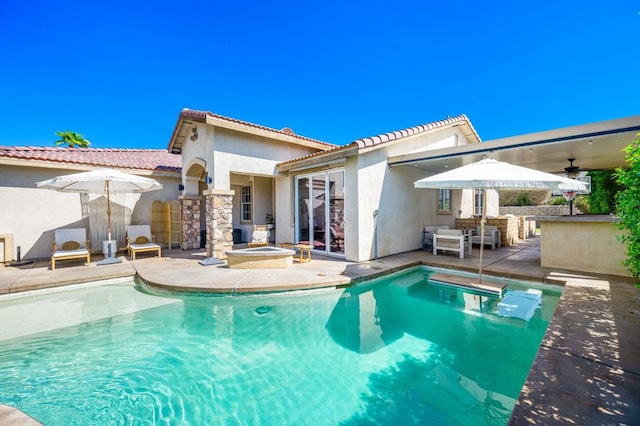 back of property with a pool with hot tub, ceiling fan, exterior bar, and a patio area