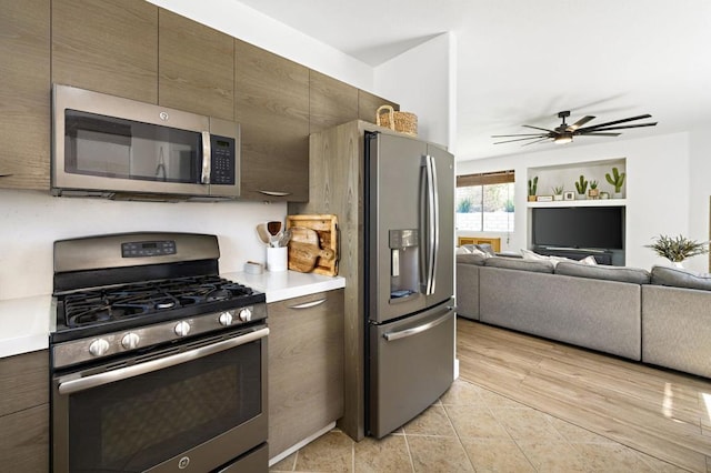 kitchen featuring ceiling fan, stainless steel appliances, and dark brown cabinets