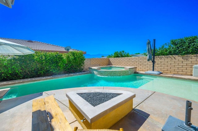 view of swimming pool with an in ground hot tub and a fire pit