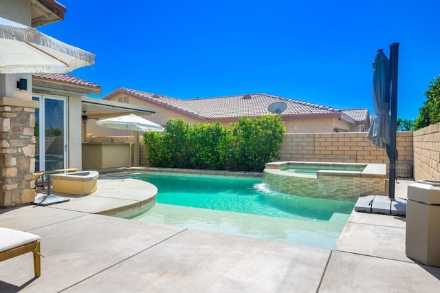 view of pool with area for grilling, a patio, and an in ground hot tub