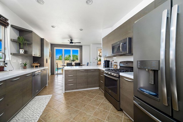 kitchen featuring ceiling fan, stainless steel appliances, kitchen peninsula, and dark brown cabinetry