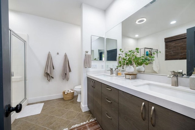 bathroom with tile patterned floors, toilet, vanity, and an enclosed shower