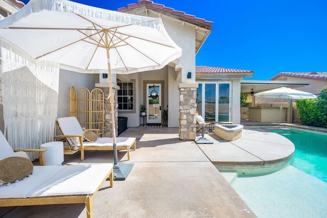 rear view of house with area for grilling and a patio