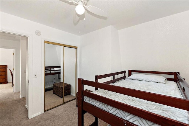 bedroom with ceiling fan, a closet, and light carpet