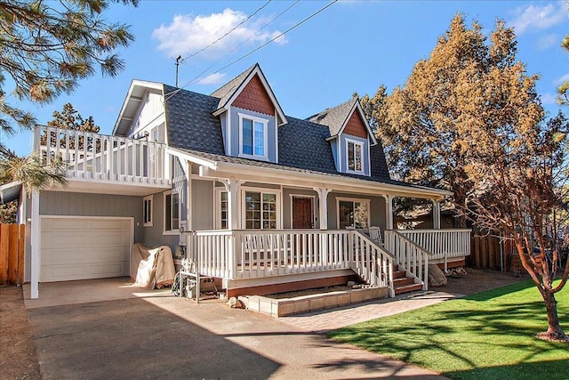 view of front of home with a front yard, covered porch, and a garage