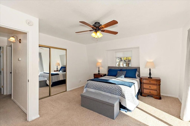 bedroom with ceiling fan, a closet, and light carpet