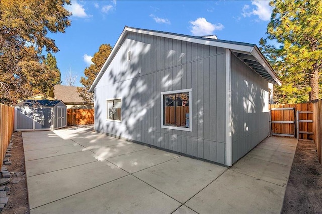 view of side of home featuring a patio area and a shed