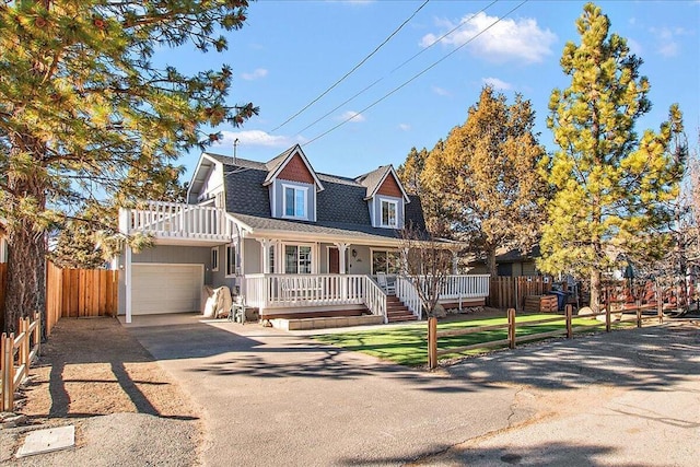 view of front of home with covered porch, a front lawn, and a garage