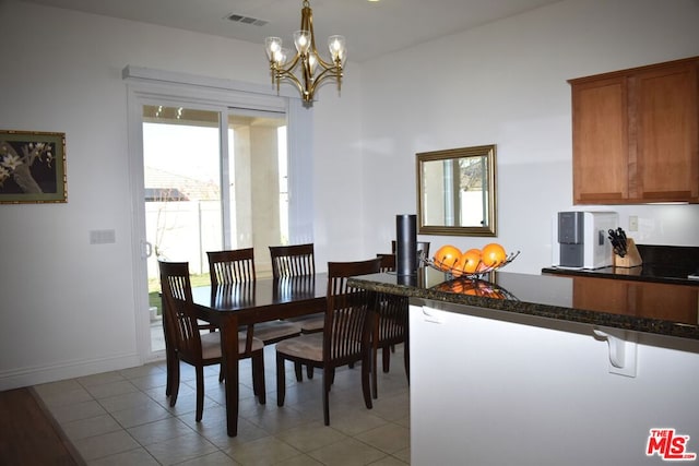 dining room with light tile patterned floors and a chandelier