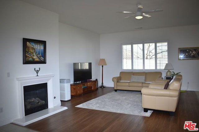 living room with dark wood-type flooring and ceiling fan