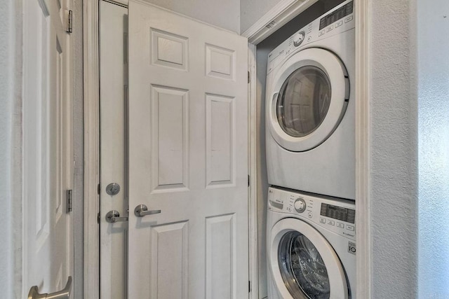 clothes washing area featuring stacked washer / dryer