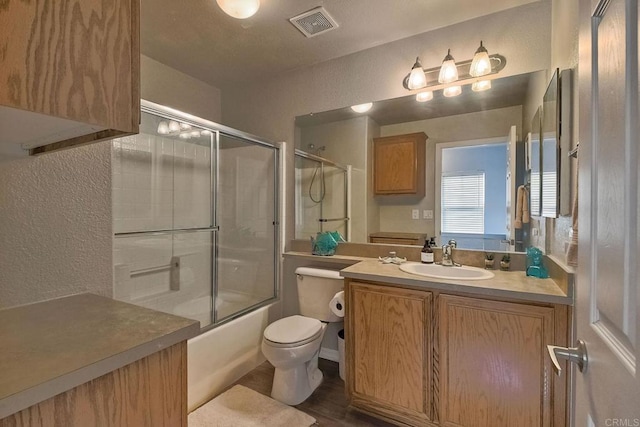 full bathroom featuring tile patterned flooring, vanity, combined bath / shower with glass door, and toilet