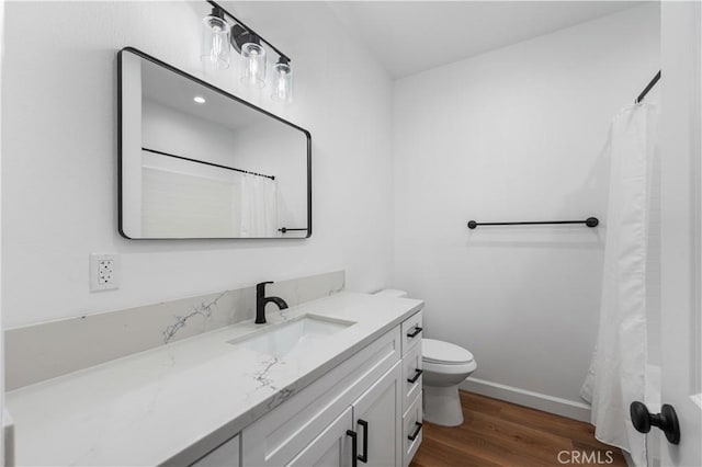 bathroom featuring hardwood / wood-style floors, toilet, vanity, and walk in shower