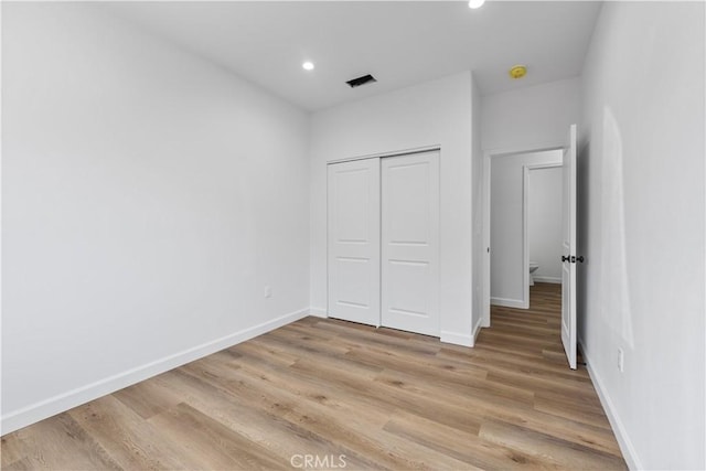 unfurnished bedroom featuring a closet and light hardwood / wood-style flooring