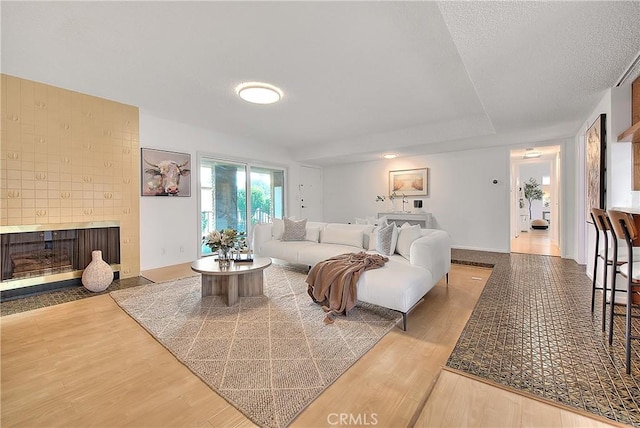 living room with a brick fireplace and light hardwood / wood-style flooring