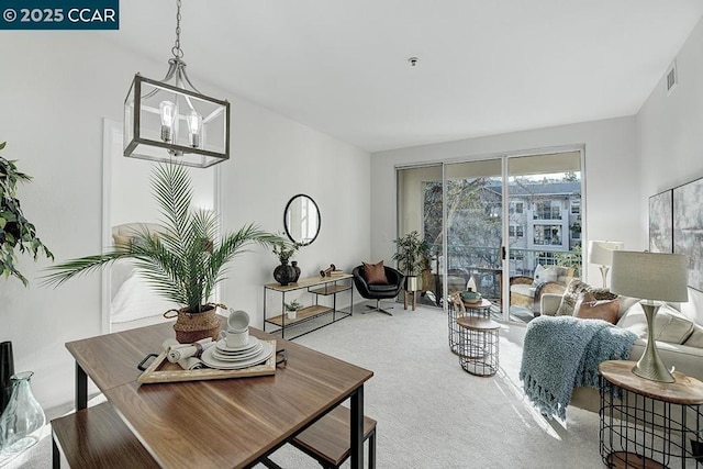 living room with light carpet and an inviting chandelier