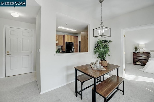 carpeted dining area featuring an inviting chandelier